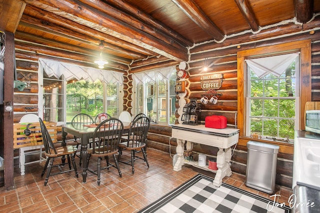 sunroom / solarium featuring beamed ceiling, wood ceiling, and a healthy amount of sunlight