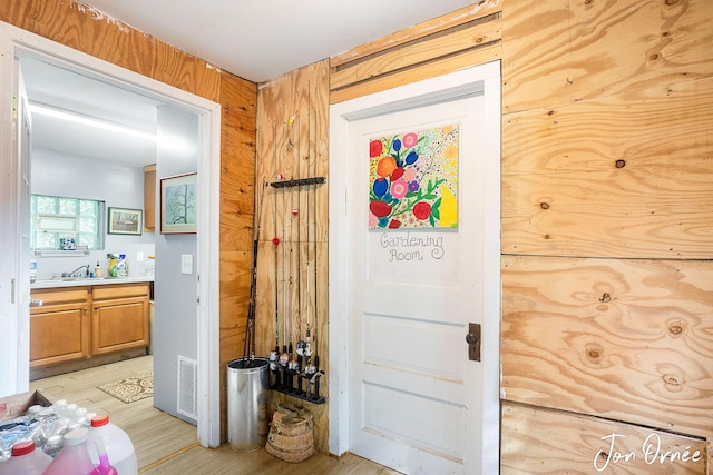 hall with sink and light hardwood / wood-style flooring