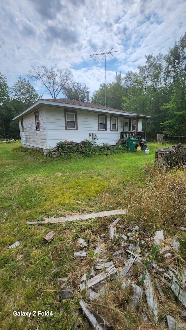 exterior space featuring a wooden deck and a lawn