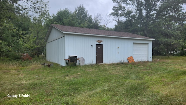 view of outbuilding with a yard and a garage