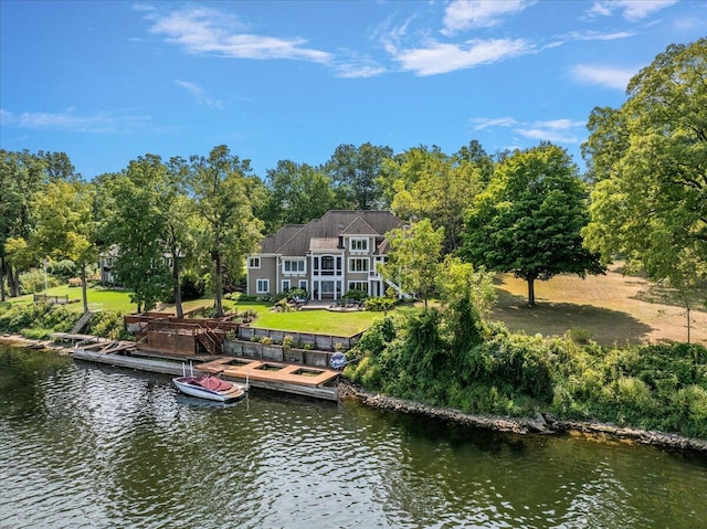 view of dock with a water view and a lawn