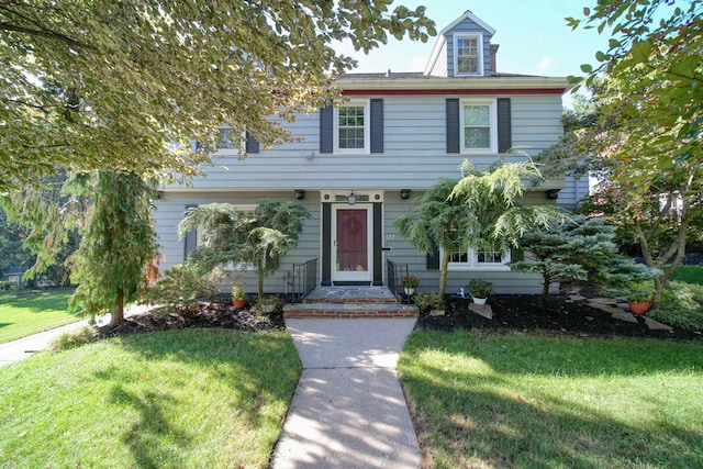 colonial inspired home with a front lawn