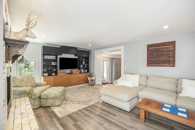 living room featuring built in shelves and hardwood / wood-style flooring