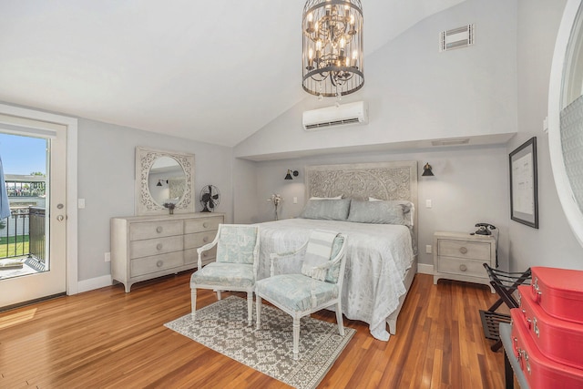 bedroom with an AC wall unit, access to outside, hardwood / wood-style floors, and lofted ceiling