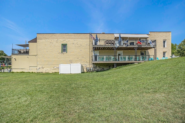 back of property featuring a lawn and a deck