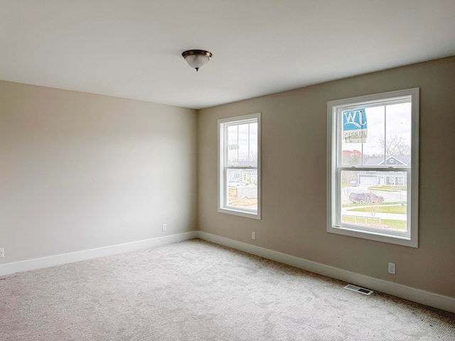 spare room featuring light carpet