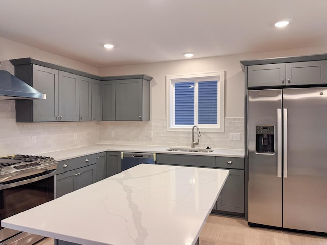 kitchen featuring sink, gray cabinetry, light stone counters, stainless steel appliances, and decorative backsplash