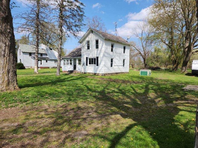 rear view of property with a yard