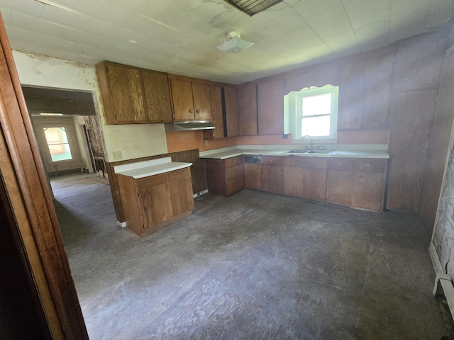 kitchen featuring brown cabinetry, a wealth of natural light, light countertops, and a sink