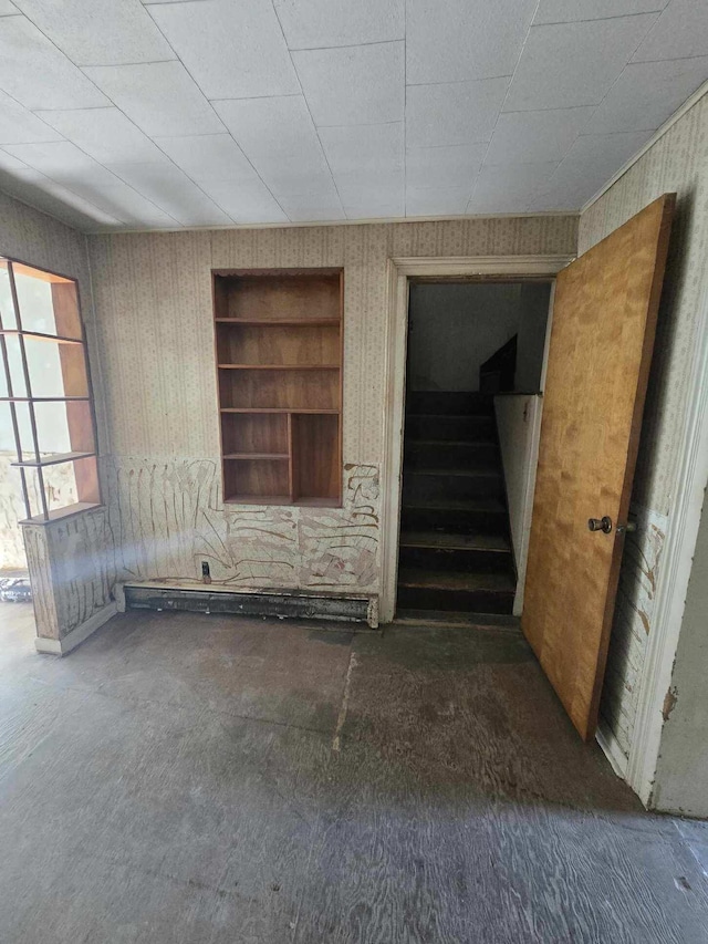 spare room featuring stairs and wallpapered walls