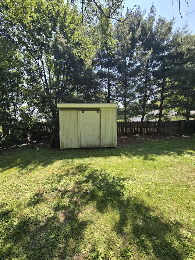 view of yard with a storage shed, an outdoor structure, and fence