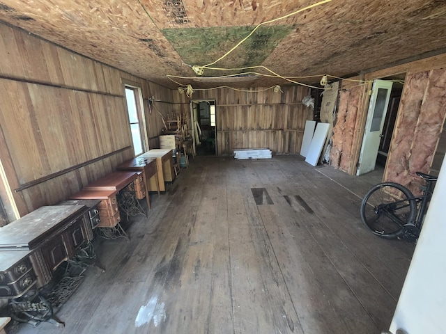 interior space with dark hardwood / wood-style flooring and wooden walls