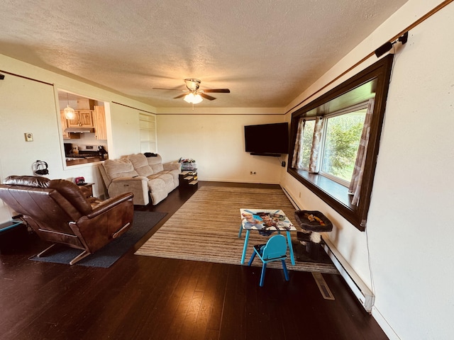 living room featuring baseboard heating, ceiling fan, dark hardwood / wood-style flooring, and a textured ceiling