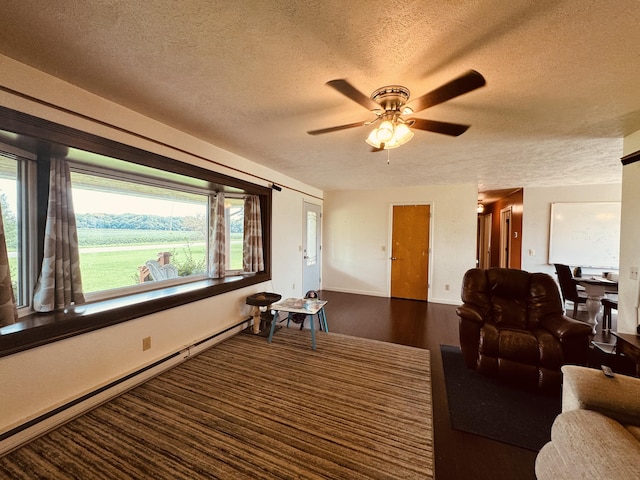 living room with a baseboard radiator, a healthy amount of sunlight, and a textured ceiling