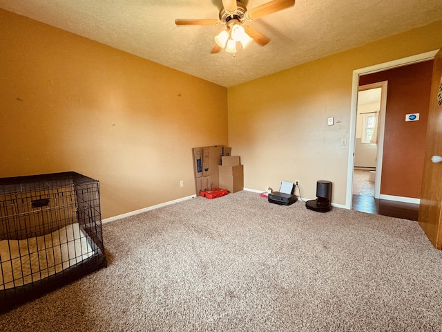 carpeted empty room with ceiling fan and a textured ceiling