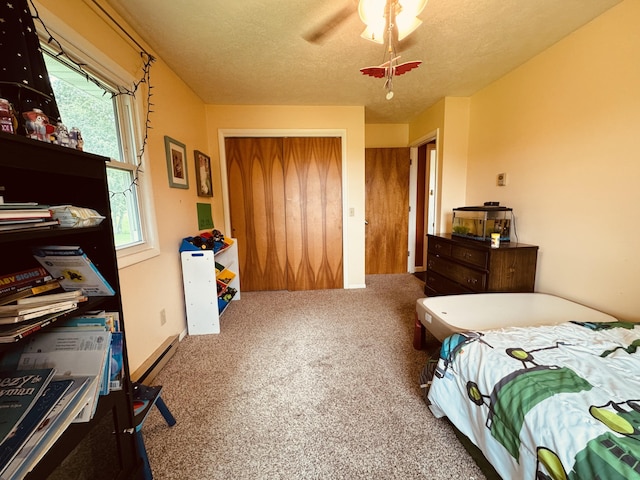 carpeted bedroom featuring a textured ceiling and ceiling fan