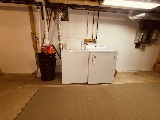 basement with electric panel and washing machine and clothes dryer