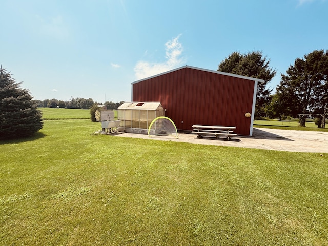 view of outdoor structure with a rural view and a lawn