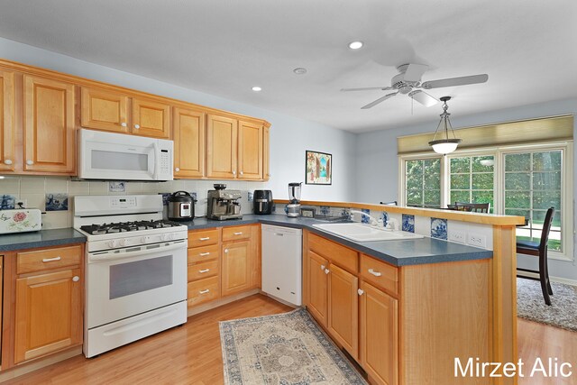 kitchen with kitchen peninsula, backsplash, white appliances, and ceiling fan