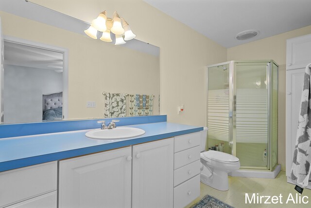 bathroom with an enclosed shower, vanity, toilet, and tile patterned flooring