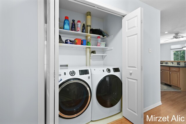 laundry room featuring ceiling fan, sink, washer and dryer, and light hardwood / wood-style floors