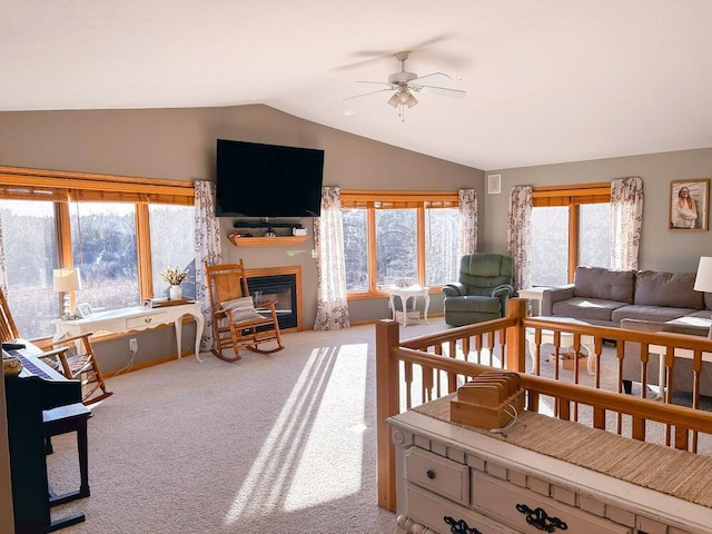 interior space with ceiling fan, carpet flooring, and vaulted ceiling