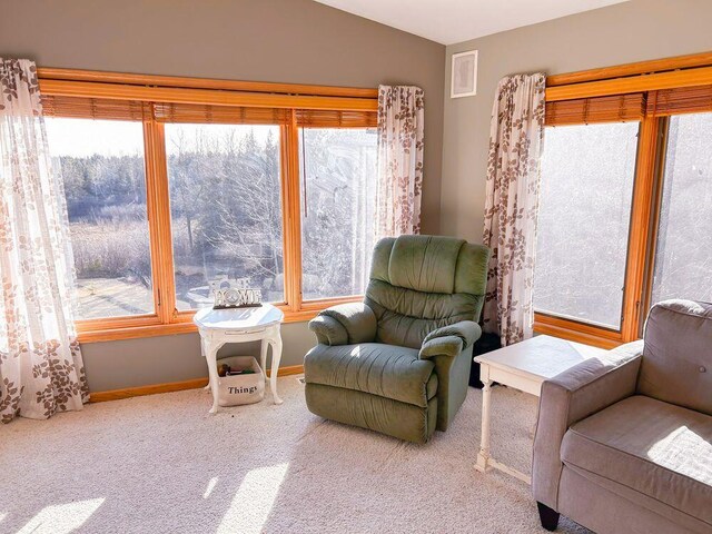 sitting room featuring carpet flooring and vaulted ceiling