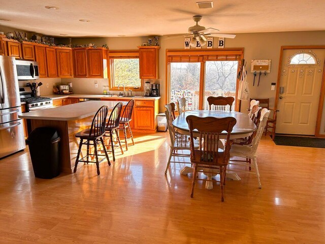 dining room with light hardwood / wood-style floors and ceiling fan