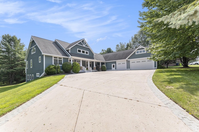 shingle-style home featuring a garage, a porch, concrete driveway, and a front yard