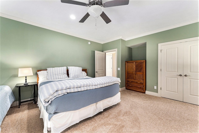 bedroom with ceiling fan, ornamental molding, a closet, and light carpet