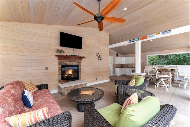 living room with wooden walls, lofted ceiling, ceiling fan, wooden ceiling, and an outdoor stone fireplace