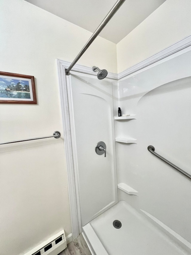 bathroom featuring hardwood / wood-style floors, a baseboard heating unit, and a shower