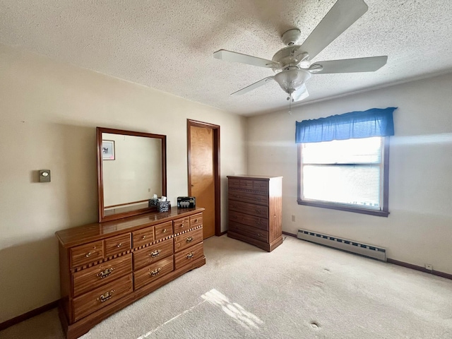 carpeted bedroom with a baseboard heating unit, ceiling fan, and a textured ceiling