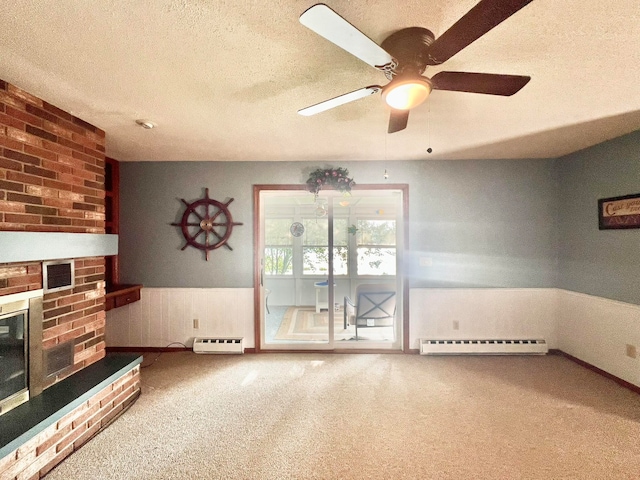 carpeted living room with ceiling fan, baseboard heating, a textured ceiling, and a brick fireplace