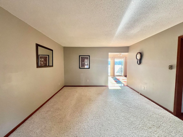 carpeted empty room with a textured ceiling