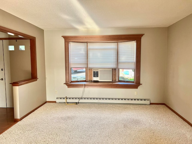 spare room with cooling unit, a textured ceiling, carpet flooring, and a baseboard radiator