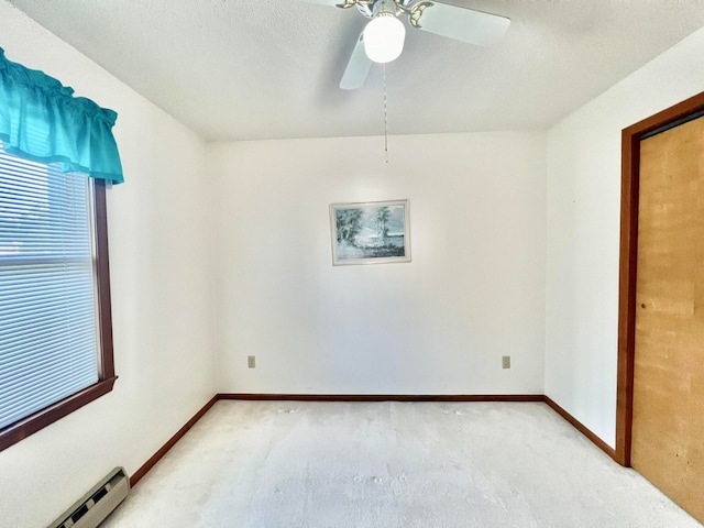 spare room with ceiling fan, light colored carpet, and a baseboard radiator