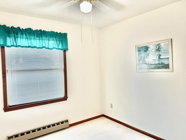 carpeted spare room with a baseboard heating unit and ceiling fan