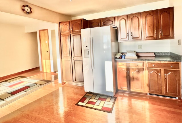 kitchen with light wood-type flooring and white refrigerator with ice dispenser