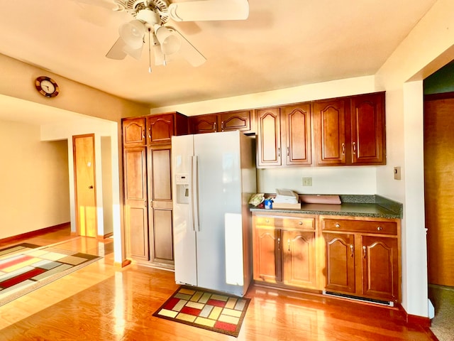 kitchen featuring white refrigerator with ice dispenser, ceiling fan, and light hardwood / wood-style floors