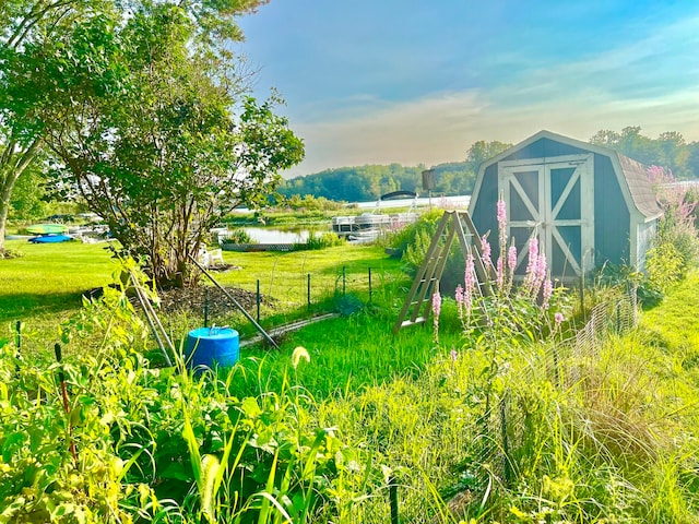 view of yard featuring a shed and a water view