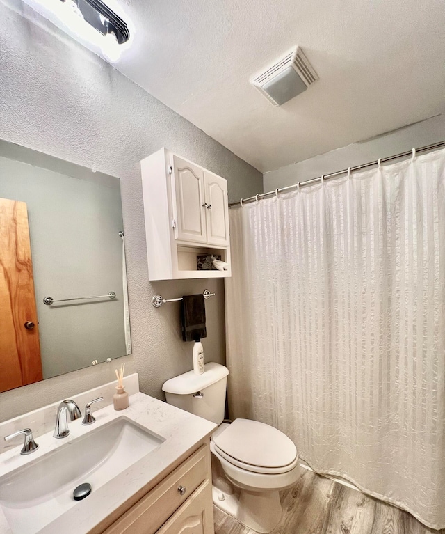 bathroom featuring vanity, toilet, and hardwood / wood-style floors