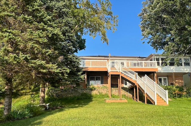 back of property featuring a lawn and a deck