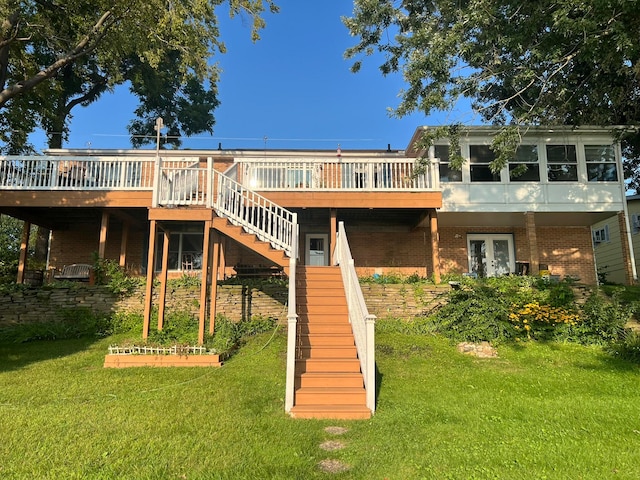 back of property with a yard and a wooden deck