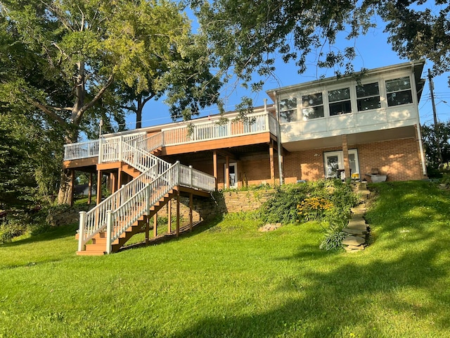 rear view of property with a wooden deck and a lawn