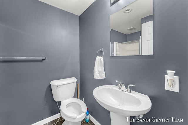 bathroom featuring tile patterned flooring, toilet, and sink