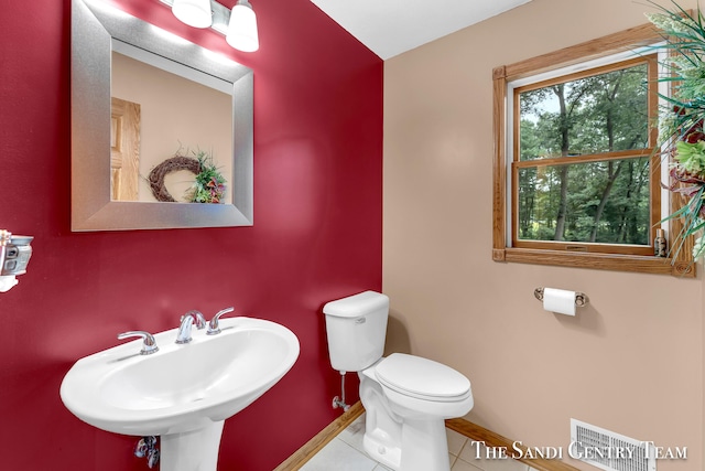 bathroom with toilet, tile patterned floors, and sink