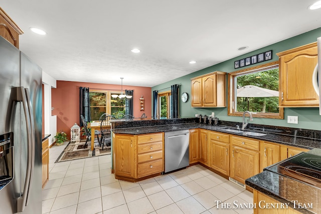 kitchen with kitchen peninsula, stainless steel appliances, sink, an inviting chandelier, and hanging light fixtures