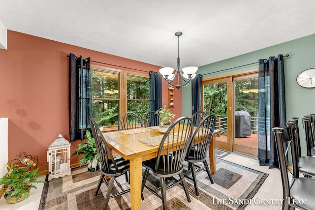 dining area featuring a notable chandelier, light tile patterned floors, and a textured ceiling