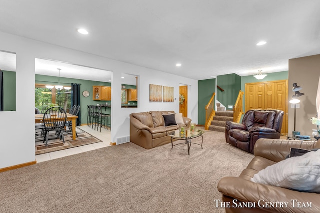 carpeted living room with a chandelier